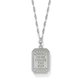 A silver pendant necklace featuring a rectangular tag-style pendant with the engraved text 'HERE COMES THE SUN' and a sunburst design, shown on a white background.