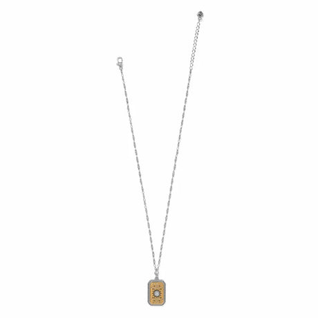 A silver-toned chain necklace with a rectangular pendant featuring a gold-toned textured background and a central clear gemstone, displayed on a solid white background.