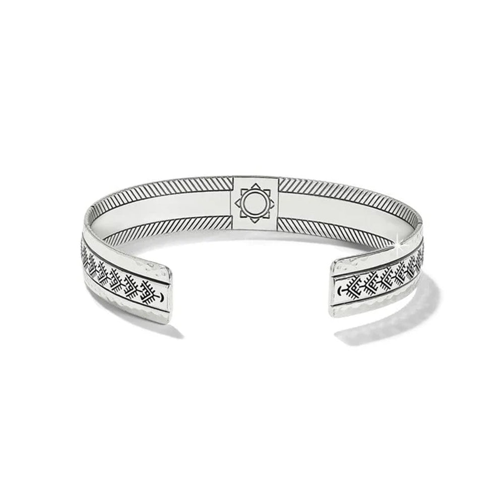 Silver bracelet with engraved patterns on a white background
