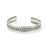 Silver bracelet with intricate patterns on a white background