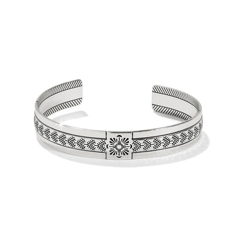 Silver bracelet with intricate patterns on a white background