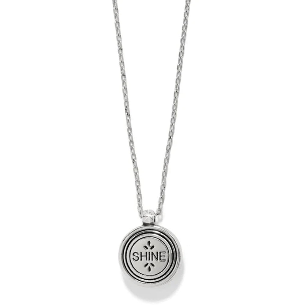 Silver necklace with a round pendant engraved with 'SHINE' on a white background
