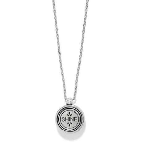 Silver necklace with a round pendant engraved with 'SHINE' on a white background