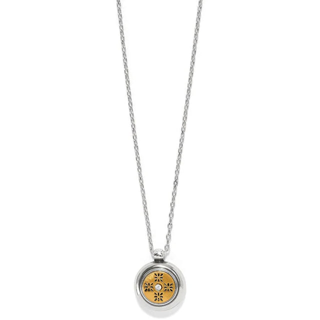 Silver necklace with a round pendant featuring a floral design on a white background