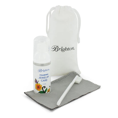Jewelry care kit with bottle, cloth, and pouch on a white background