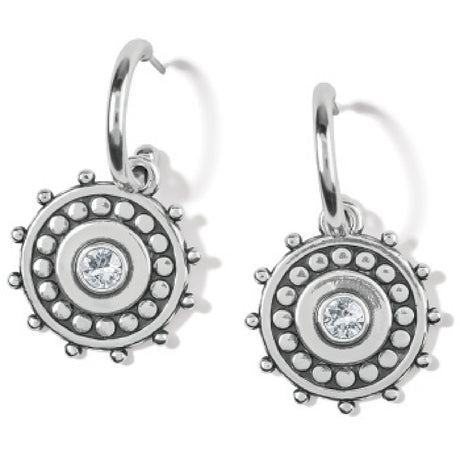 Silver earrings with circular design and clear gemstone on a white background