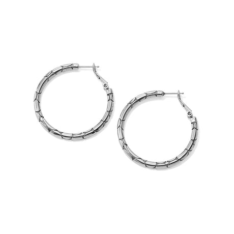 A pair of silver-toned textured hoop earrings with a segmented, beaded outer edge and post-back closures, shown on a plain white background.