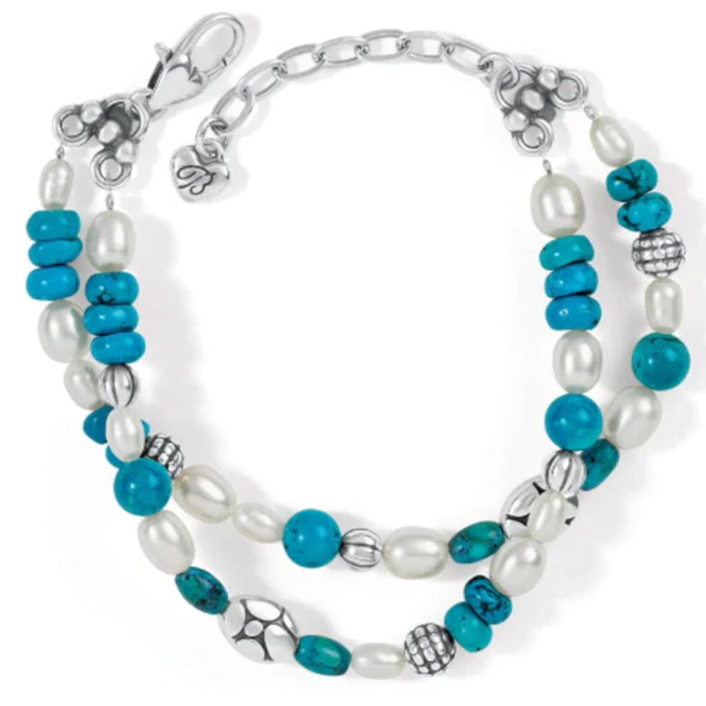 Multistrand bracelet with turquoise beads, pearls, and silver accents on a white background