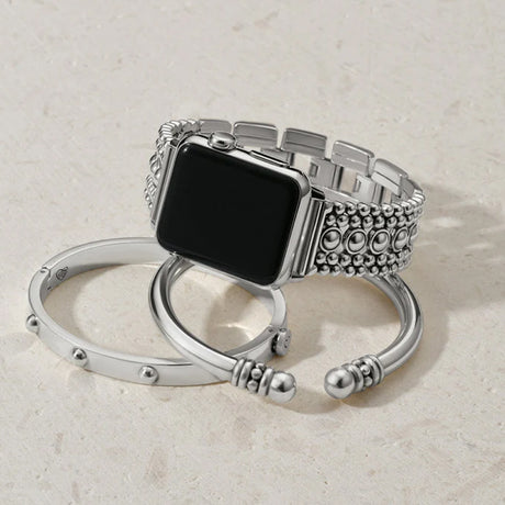 Silver watch band with intricate design on a light beige background