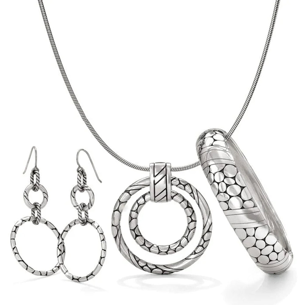 Silver jewelry set including a necklace, pendant, earrings, and cylindrical piece on a white background