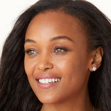 Close-up of a woman with a diamond earring on a white background