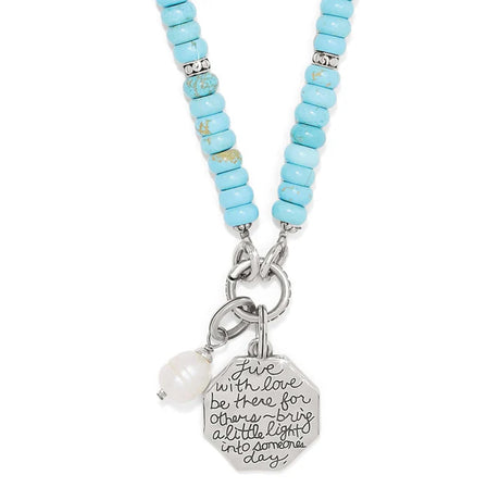 Necklace with turquoise beads and a silver charm on a white background
