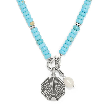 Necklace with turquoise beads and shell charm on a white background