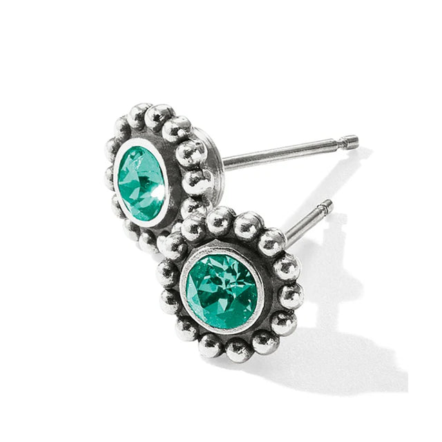 Silver earrings with green gemstones on a white background