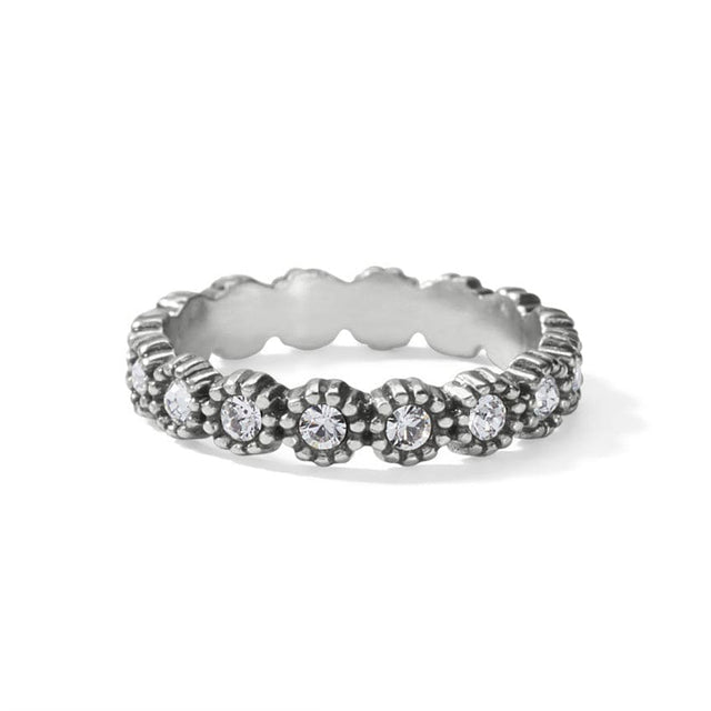 Silver ring with floral design and embedded stones on a white background