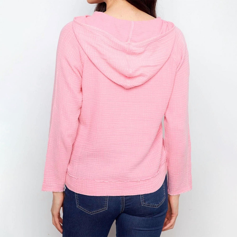 Pink hooded sweater worn by a person on a white background