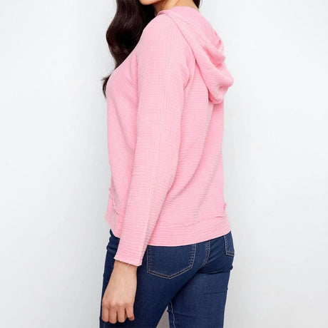 Person wearing a pink hoodie and blue jeans on a white background