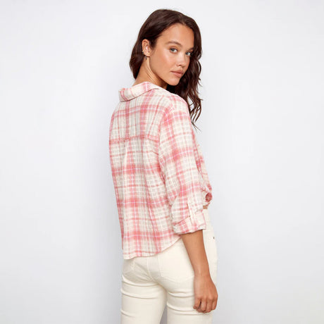 Woman wearing a pink and white plaid shirt against a white background