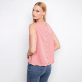 Woman wearing a pink sleeveless top with buttons on a white background