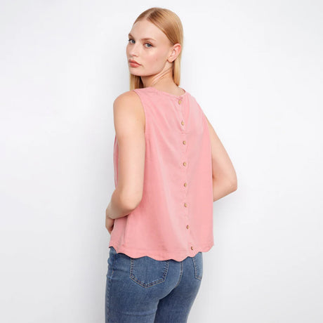 Woman wearing a pink sleeveless top with buttons on a white background