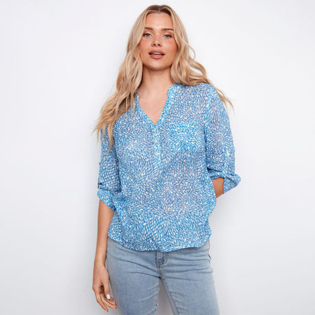 Woman wearing a blue floral blouse against a white background