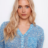 Woman wearing a blue floral blouse against a white background