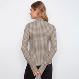 A woman shown from the back wearing a beige and black checkered long-sleeve mock neck top, paired with black pants, against a plain white background.