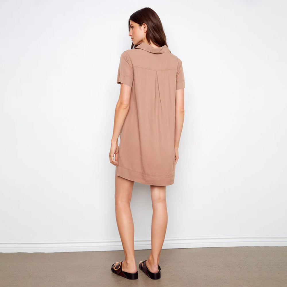 Woman wearing a beige dress against a white background