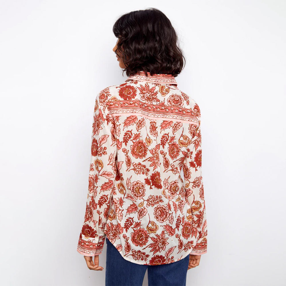 Person wearing a floral patterned shirt on a white background