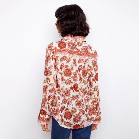 Person wearing a floral patterned shirt on a white background