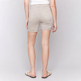Person wearing beige shorts on a plain background