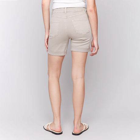 Person wearing beige shorts on a plain background