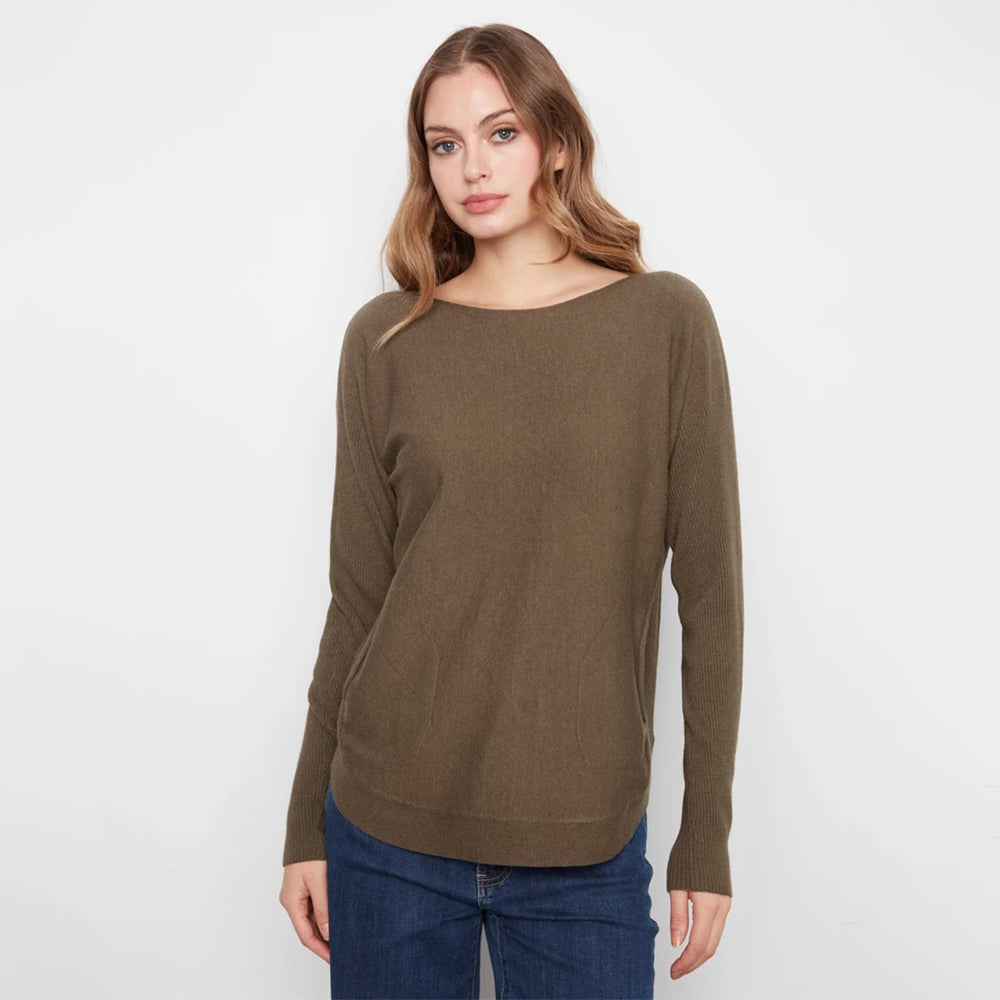 A woman modeling a long-sleeve boat-neck knit sweater in olive brown, paired with blue jeans, against a plain white studio background.