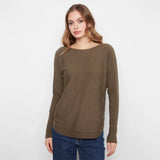 A woman modeling a long-sleeve boat-neck knit sweater in olive brown, paired with blue jeans, against a plain white studio background.