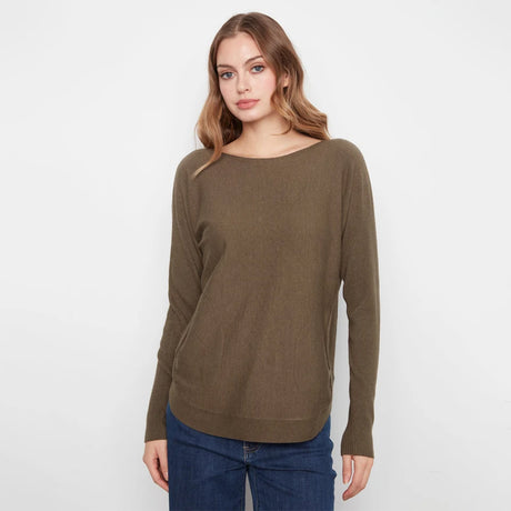 A woman modeling a long-sleeve boat-neck knit sweater in olive brown, paired with blue jeans, against a plain white studio background.