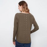 A woman shown from the back wearing a long-sleeve knit top in a muted taupe-brown color, featuring a vertical row of metal eyelets with laces down the back. She is wearing blue jeans against a plain white studio background.