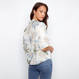 Woman wearing a floral blouse and jeans on a white background