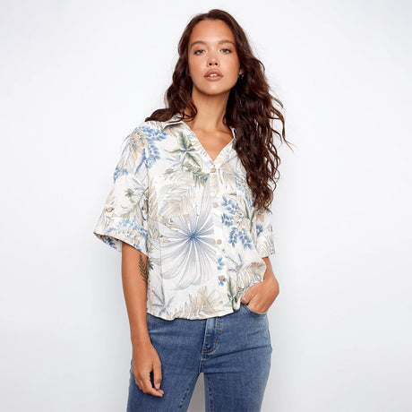 Woman wearing a floral blouse and jeans on a white background
