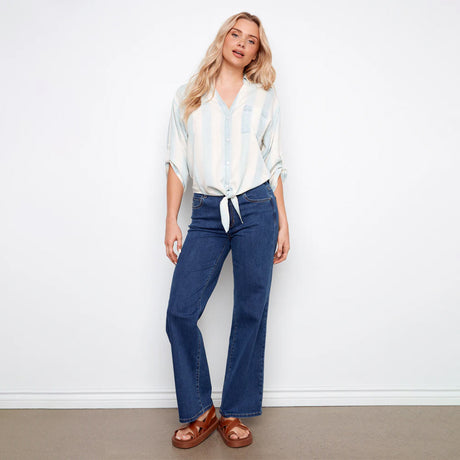 Woman wearing a striped shirt and blue jeans against a white background