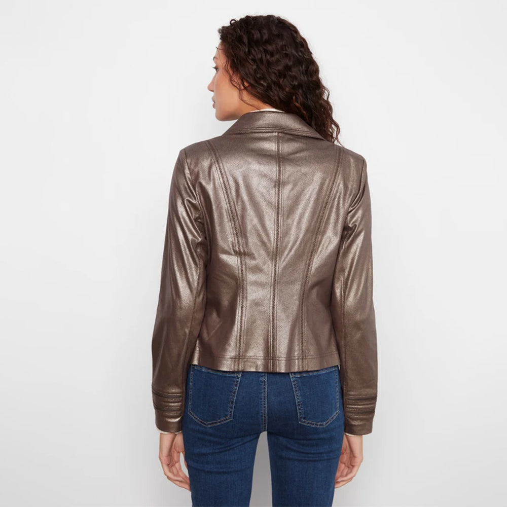 A woman viewed from the back wearing a metallic taupe-brown faux leather jacket and blue jeans, standing against a plain white studio background.