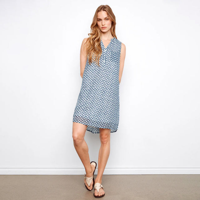 Woman wearing a blue patterned dress against a white background