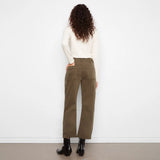 A model viewed from behind wearing olive green wide-leg cropped pants, a cream long-sleeve top, and black ankle boots, standing against a plain white wall.