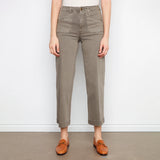 Person wearing beige pants and brown shoes on a plain background