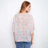 Woman wearing a patterned blouse with a white background