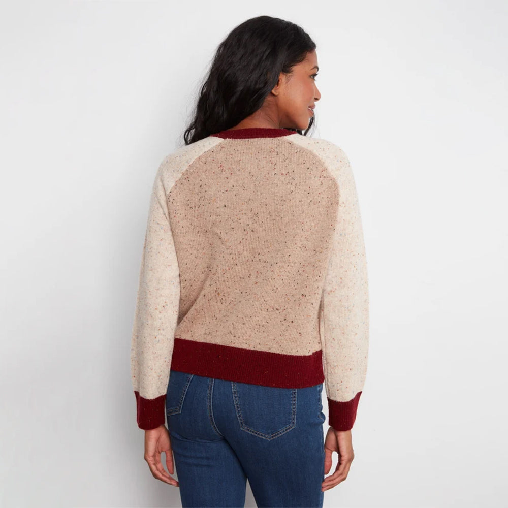 A woman shown from the back wearing a color-blocked knit sweater with a speckled beige body, burgundy collar, hem, and cuffs, paired with blue jeans against a plain white background.
