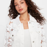 Woman wearing a white lace-trimmed jacket on a white background