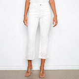 Person wearing white pants with decorative hem on a plain background