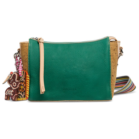 Green leather crossbody bag with cork accents and decorative charm on a white background