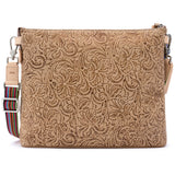 A tan embossed leather pouch with a floral paisley pattern, shown open to reveal a navy blue starry interior lining and a brand label reading 'CONSUELA'.