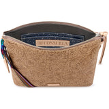 A tan embossed leather pouch with a floral paisley pattern, shown open to reveal a navy blue starry interior lining and a brand label reading 'CONSUELA'.